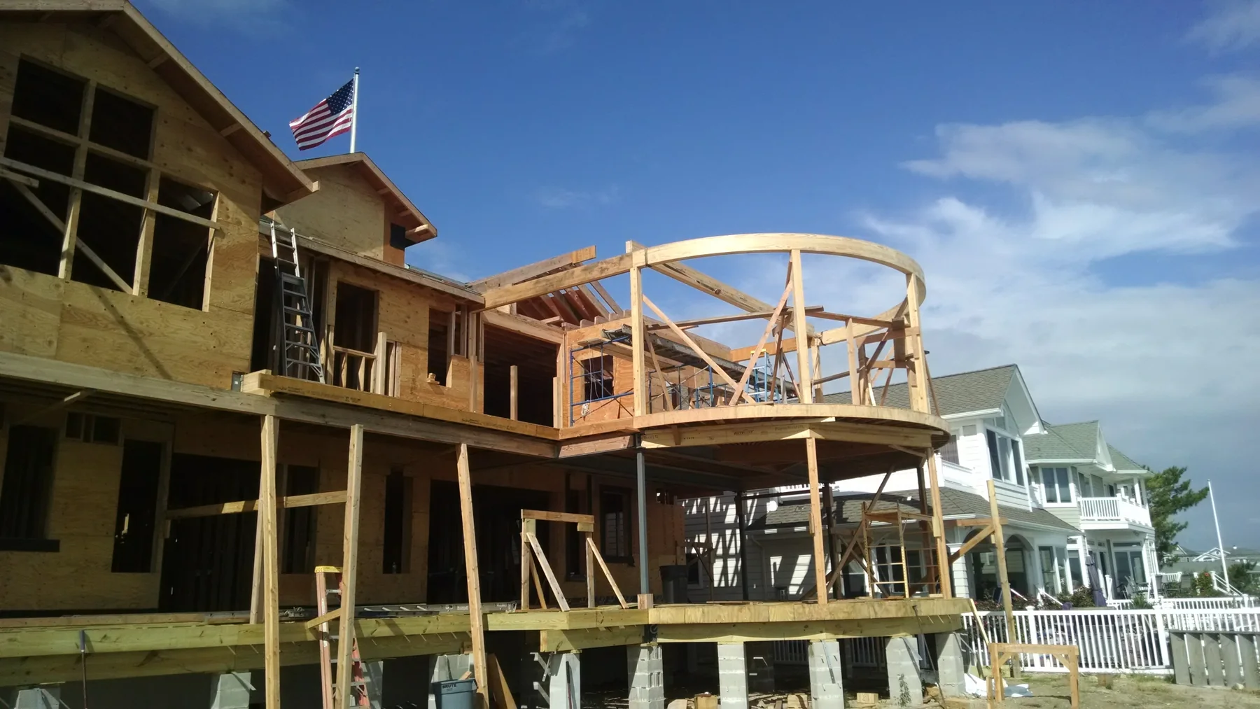 Second-story curved deck framing on a large waterfront build