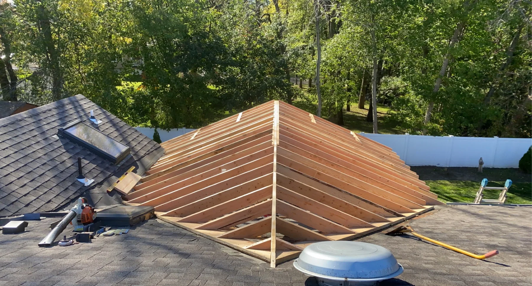 Overhead view of fresh roof rafters tied into an existing roof