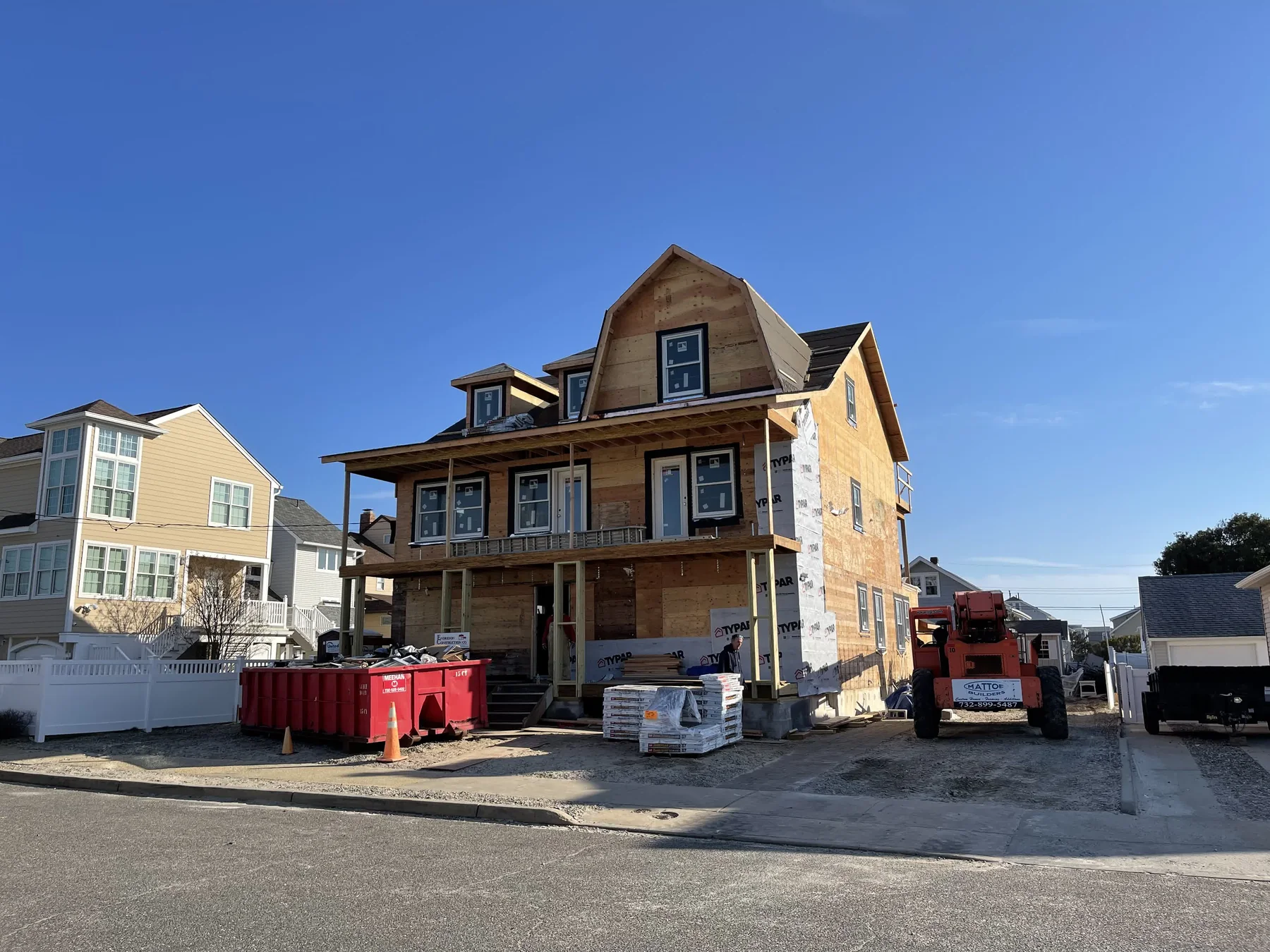 Street view of a large Shore build with crew and site logistics in progress