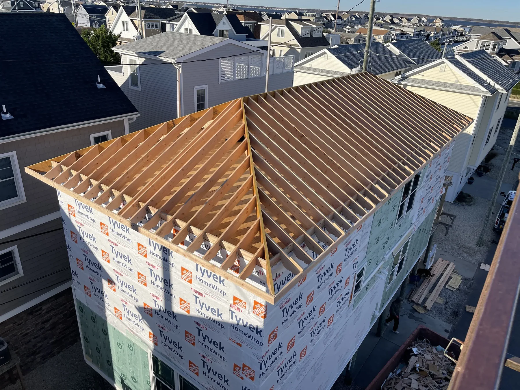Aerial view of wrapped coastal roof framing over a shore neighborhood